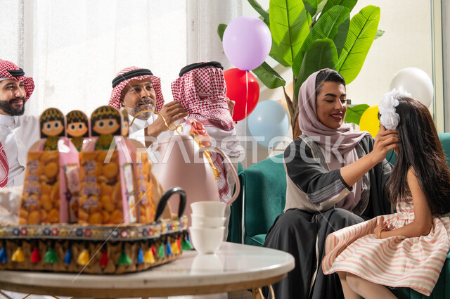 صوره مقربة لسلة قرقيعان وتوزيعات العيد , تجمع أسري لعائلة عربية خليجية سعودية تحتفل في العيد, البهجة والفرحة بين الاهل والاقارب, ايماءات تدل على الفرح و السرور, اجواء العيد في المجتمع العربي السعودي, الزيارات والتجمعات في الأعياد والمناسبات .