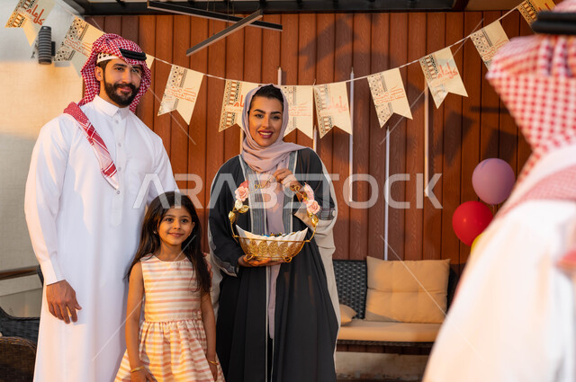 ايماءات تدل على السعادة, عائلة عربية سعودية خليجية تقف لاستقبال الضيوف , الزيارات والتجمعات الأسريه في العيد , الاحتفال بقدوم العيد المبارك, ديكورات وزينة العيد, المناسبات والاعياد الاسلاميه, اجواء عائليه سعيده .