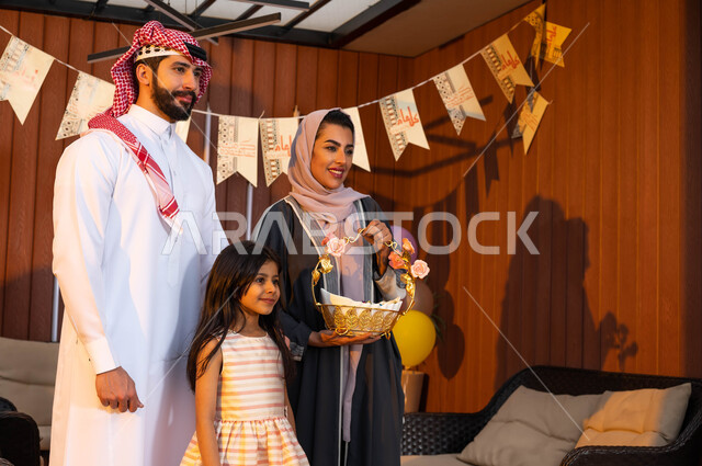 الاحتفال بقدوم العيد المبارك, عائلة عربية سعودية خليجية تقف لاستقبال الضيوف , الزيارات والتجمعات الأسريه في العيد , ديكورات وزينة العيد, المناسبات والاعياد الاسلاميه, اجواء عائليه سعيده .