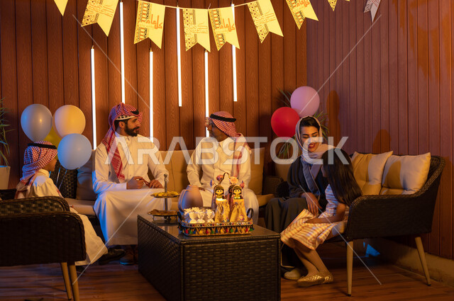 Family visits and gatherings in the living room, decorations and decorations for the happy Eid, a Saudi Gulf Arab family celebrating the Eid, Islamic holidays and occasions, congratulations on the advent of the Eid.