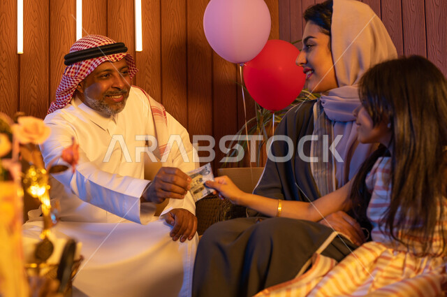  ايماءات تدل على الفرح والسرور, رجل مسن عربي سعودي خليجي يقوم بتقديم العيدية للاحفاد, التهنئةبقدوم العيد المبارك,  الزيارات والتجمعات العائلية في الأعياد والمناسبات الاسلامية