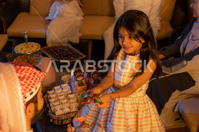 اكرام الضيوف و حسن الاستقبال, فتاة عربية خليجية سعودية تقوم بتقديم شوكولا و حلوى العيد , ايماءات تدل على الفرح والسعاده, الزيارات و التجمعات الاسريه, التهنئه بقدوم العيد في الأعياد والمناسبات الاسلامية السعيدة