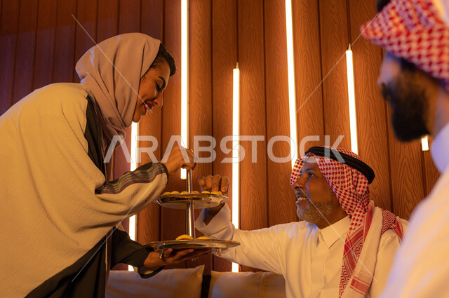  تقديم حلوى وكعك العيد , حسن استقبال واكرام الضيوف, عائلة عربية سعودية خليجية تحتفل بالعيد, ايماءات تدل على الفرح والسعاده, الزيارات و التجمعات الاسريه, التهنئه بقدوم العيد في الأعياد والمناسبات الاسلامية السعيدة .