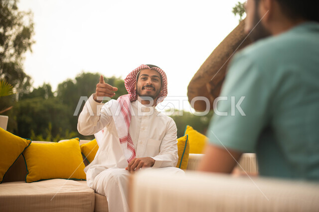 إيماءات يدين تدل على الإشارة إلى شيء ، رجلان سعوديان عربيان خليجيان سعوديان  يقضون أوقات ممتعة في الهواء الطلق  ، جلسات وانشطة شبابية، نقاشات وحوارات، وناسة وتعارف وكشتة شباب، الطبيعة الخضراء