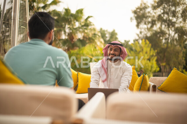 استخدام الحاسوب المحمول ، رجلان سعوديان عربيان خليجيان سعوديان يقضون أوقات ممتعة في الهواء الطلق ، جلسات وانشطة شبابية، نقاشات وحوارات، وناسة وتعارف وكشتة شباب، الطبيعة الخضراء