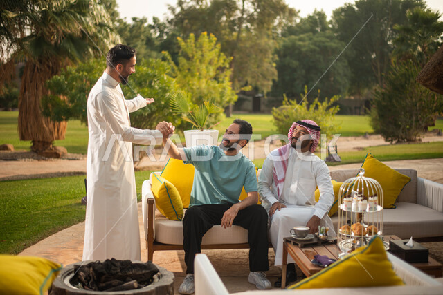 إيماءات يد تدل على المصافحة والتحية والسلام ، رجلان سعوديان عربيان خليجيان يتصافحان بسعادة ، إلقاء السلام والترحيب بين الاصدقاء ، قضاء أوقات ممتعة برفقة الأصدقاء ، وناسة وتعارف وكشتة شباب، الطبيعة الخضراء