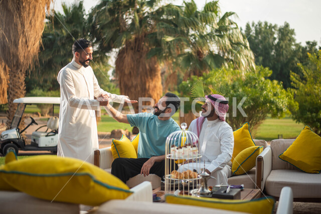 مجموعة رجال عرب خليجيون سعوديون إيماءات يد تدل على المصافحة ، إلقاء السلام والترحيب بين الاصدقاء ، قضاء أوقات ممتعة برفقة الأصدقاء ، التحية والسلام ،  وناسة وتعارف وكشتة شباب، الطبيعة الخضراء