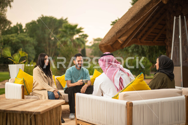 قضاء أوقات ممتعة برفقة الاصدقاء وعطلة صيفية سعيدة ، مجموعة من الشباب والبنات العرب الخليجيون السعوديون يستمتعون بتبادل الحديث في احد المقاهي في السعودية ، المشروبات الساخنة، دردشة وحوارات.