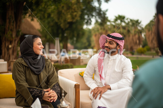 مجموعة من الأصدقاء العرب الخليجيون السعوديون يستمتعون بتبادل الحديث في احد المقاهي في السعودية ، المشروبات الباردة ، عطلة صيفية سعيدة ، قضاء أوقات ممتعة برفقة الاصدقاء ، دردشة وحوارات.