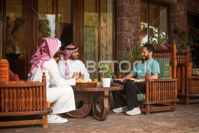 مجموعة من الاصدقاء العرب الخليجيون السعوديون في احد المقاهي في السعودية الاستمتاع بتبادل الحديث  ، قضاء اوقات ممتعة برفقة الاصدقاء ، نقاشات وحوارات ، المشروبات الباردة ، ايماءات تدل على الفرح والسعادة.