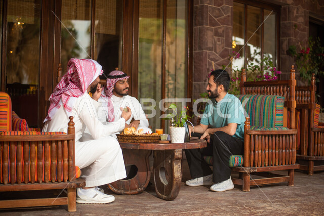 مجموعة اصدقاء عرب خليجيون سعوديون في احد المقاهي في السعودية الاستمتاع بتبادل الحديث  ، قضاء اوقات ممتعة برفقة الاصدقاء ، نقاشات وحوارات ، المشروبات الباردة ، ايماءات تدل على الفرح والسعادة.