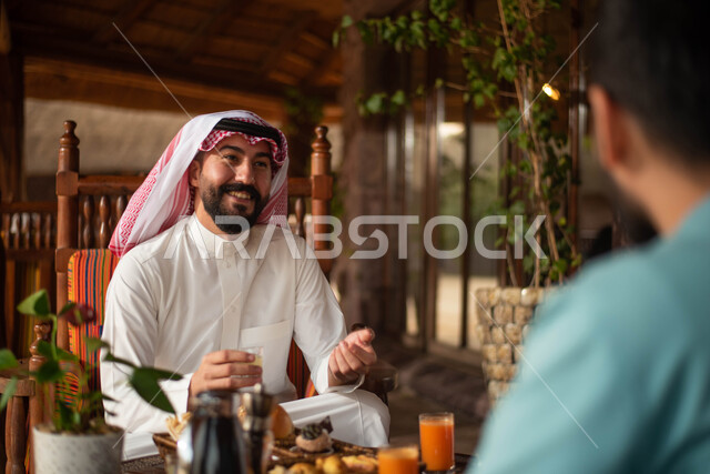 صورة مقربة لمجموعة شباب عرب خليجيون سعوديون الاستمتاع بتبادل الحديث في احد المقاهي في السعودية ، قضاء اوقات ممتعة برفقة الاصدقاء ، المشروبات الباردة ، نقاشات وحوارات ، أجواء شبابية في مقهى سعودي.