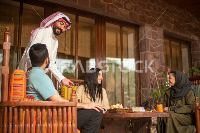 Saudi Gulf Arab friends enjoying an exchange of conversation in a Saudi cafe, cold drinks, a Saudi diwaniya, discussions and dialogues, spending enjoyable times, people, acquaintance and a happy atmosphere in a Saudi cafe