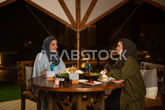 بنات من العرب الخليجيون السعوديون يستمتعون بتبادل الحديث في احد المقاهي في السعودية ، المشروبات الباردة ، قضاء أوقات ممتعة برفقة الاصدقاء ، دردشة وحوارات ، عطلة صيفية سعيدة