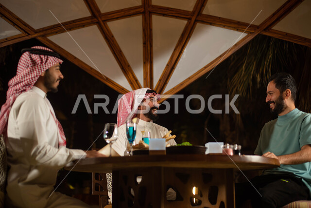  دردشة وحوارات ، مجموعة من الشباب العرب الخليجيون السعوديون يستمتعون بتبادل الحديث في احد المقاهي في السعودية ، المشروبات الباردة ، قضاء أوقات ممتعة برفقة الاصدقاء ، جلسة شبابية .