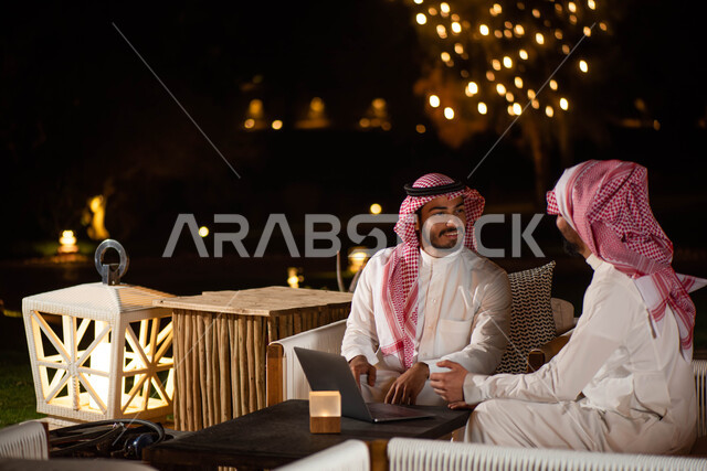 رجال أعمال من العرب الخليجيون السعوديون يجلسون على الأريكة ، انجاز مهام العمل  عبر إستخدام جهاز الحاسوب المحمول ،  الحوارات والنقاشات ، اجتماع رجال الأعمال ، تصفح الانترنت بإستخدام أجهزة تقنية حديثة ، جلسات خارجية في الهواء الطلق.