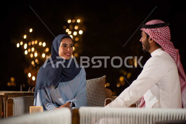  تبادل الأحاديث والحوارات ، زوجان عربيان خليجيان سعوديان في المنتجع يقضيان اوقات ممتعة  في الهواء الطلق ،  جلسة سعودية سعيدة  ،  أنشطة ترفيهية ،  ايماءات تدل على الفرح والسعادة .