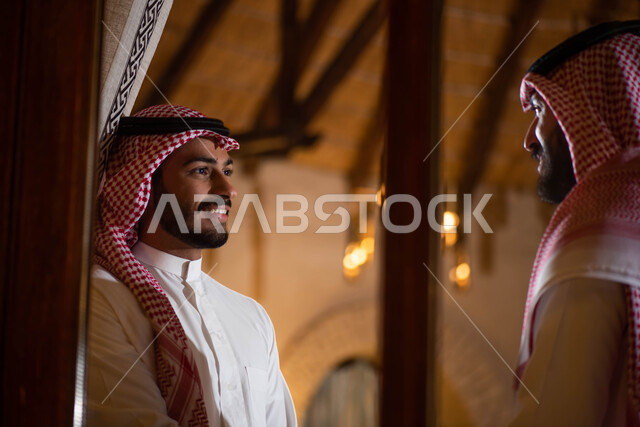 تبادل الحديث والحوارات ، رجلان عربيان خليجيان سعوديان يرتديان الزي السعودي التقليدي ، قضاء أوقات ممتعة برفقة الاصدقاء ،  أنشطة شبابية ترفيهية ، إيماءات تدل على الفرح والسعادة