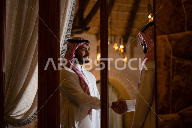  الإتفاق على صفقة عمل جديدة ، رجلان  سعوديان عربيان خليجيان يتصافحان بسعادة ، إلقاء السلام والترحيب بين الاصدقاء ، إيماءات يد تدل على المصافحة  ، قضاء أوقات ممتعة برفقة الأصدقاء ، شركاء عمل التحية والسلام.