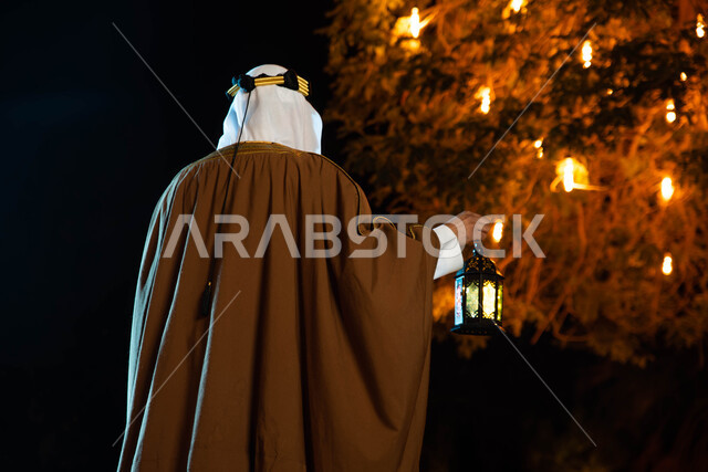 إضاءة وزينة شهر رمضان، يوم التاسيس السعودي ، صورة خلفية لشاب عربي سعودي خليجي يرتدي الزي التراثي الشعبي التقليدي يمسك بيده فانوس رمضان ، اليوم الوطني السعودي، تراثيات وشعبيات ،  أجواء رمضانية، مناسبات دينية ، اسلاميات وعبادات