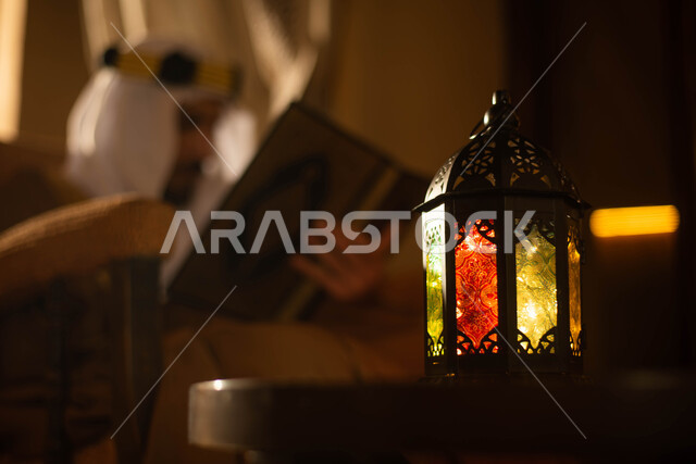 Memorizing the Holy Qur’an, the day of the Saudi founding, a Saudi Arabian Gulf man wearing a traditional Saudi folk costume and holding the Holy Qur’an, reading and reciting the Holy Qur’an, mentioning God