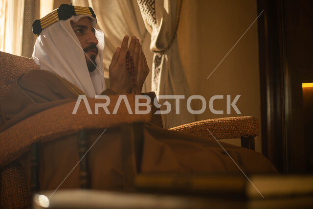 العبادة والتقرب الى الله ، شاب عربي خليجي سعودي يرتدي زي تراثي شعبي سعودي يرفع يديه لاعلى للدعاء والتضرع الى الله  ، أذكار وأدعية ، إسلاميات وعبادة ، فانوس رمضان، شهر رمضان الكريم