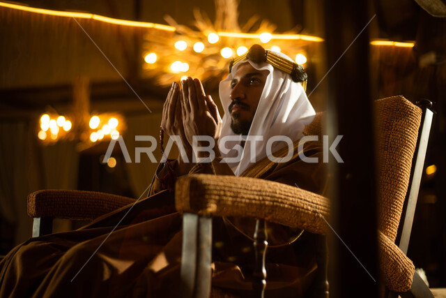 العبادة والتقرب الى الله ، رجل عربي خليجي سعودي يرتدي زي تراثي شعبي سعودي يرفع يديه لاعلى للدعاء والتضرع الى الله ، أذكار وأدعية ، إسلاميات وعبادة
