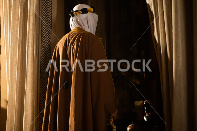 يوم التاسيس السعودي ، صورة خلفية لرجل عربي سعودي خليجي يرتدي الزي التراثي الشعبي التقليدي،  يمسك بيده السيف ، النظر الى شيء ما،  اليوم الوطني السعودي، تراثيات وشعبيات