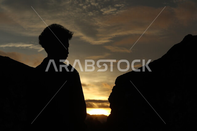 صورة ظلية لولد يقف بين الصخور الجبلية، منظر غروب الشمس على التلال الرملية، التأمل والتفكير , مناظر طبيعيه, سيلوليت، خلفيات الطبيعة 