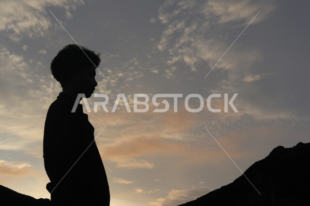 صورة ظلية لولد يقف بين الصخور الجبلية، منظر غروب الشمس على التلال الرملية، التأمل والتفكير , مناظر طبيعيه, سيلوليت، خلفيات الطبيعة 