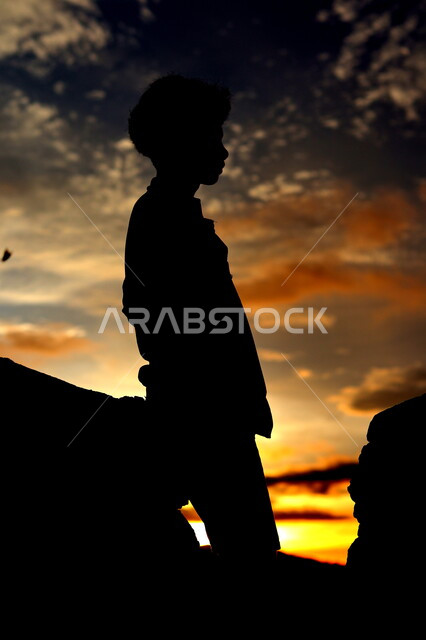 صورة ظلية لولد يقف بين الصخور الجبلية، منظر غروب الشمس على التلال الرملية، التأمل والتفكير , مناظر طبيعيه, سيلوليت، خلفيات الطبيعة 