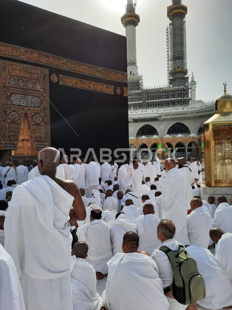 حجاج بيت الله الحرام يقومون بالصلاة في الحرم المكي الشريف في مكة المكرمة بالمملكة العربية السعودية، الكعبة المشرفة في مكة المكرمة، اداء مناسك الحج والعمرة، اماكن اسلامية مقدسة