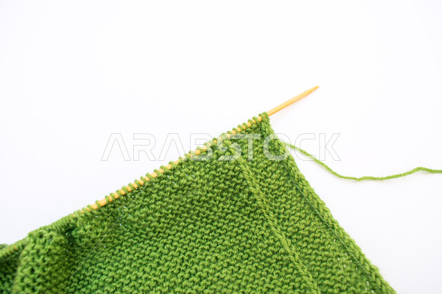 حياكة الخيوط الصوف، مهارة الخياطة والتطريز، ابرة حياكة الصوف، اعمال ومهن يدوية، قماش اخضر اللون، خلفية بيضاء