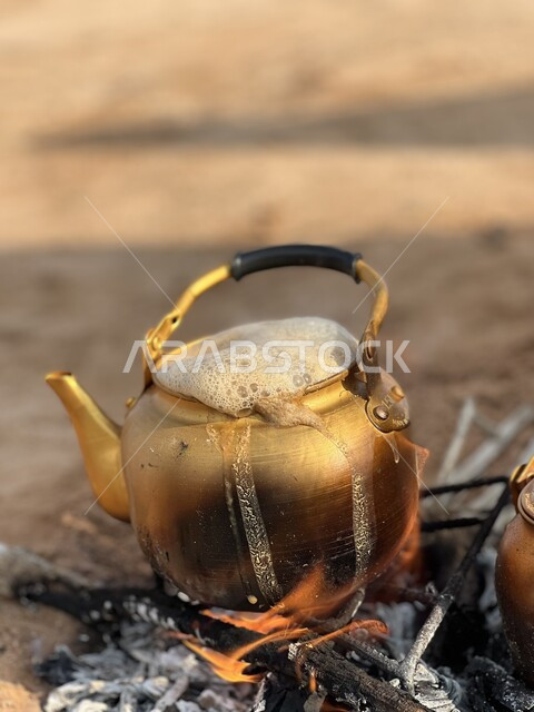 Metal golden teapot on wood fire, tea making on wood fire, burning red ...