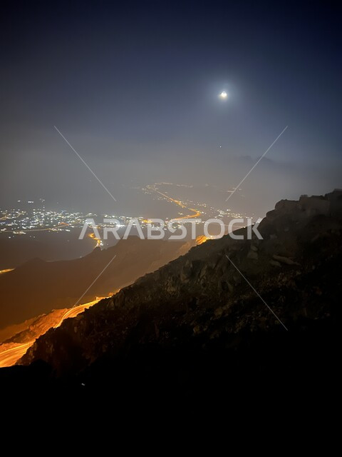 The mountains and rocky heights of Aqaba Al-Hada in Taif at night, the illuminated city of Taif at night, mountain peaks and heights, the famous landmarks of Taif, tourism in Saudi Arabia
