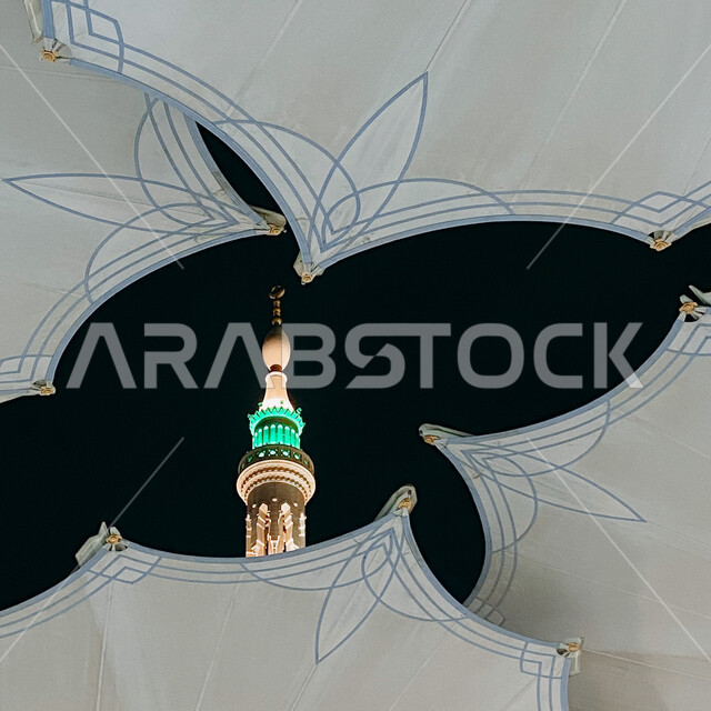 The Prophet's Mosque, a close-up of an electronic umbrella and the minaret of the Prophet's Mosque in Medina in the Kingdom of Saudi Arabia at night