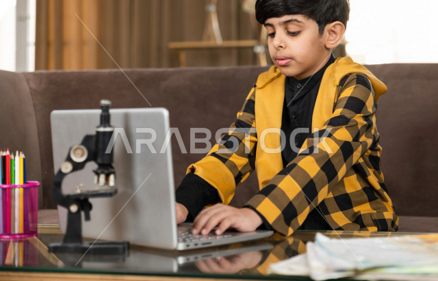 تلميذ سعودي خليجي يدرس في المنزل بتعابير وجه مختلفة ، يتابع حصص الاونلاين عن طريق الحاسوب المحمول  ، التعلم عن بعد ، مفهوم التعليم عبر الانترنت ، التعليم المنزلي اثناء الحجر الصحي و تفشي فيروس كورونا ، العزلة الذاتية 
