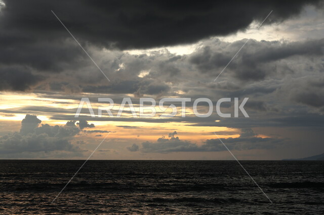 السماء الغائمة و المظلمة الملبدة بالغيوم فوق البحر, ظهور الشفق الاحمر وقت غروب الشمس, مناظر طبيعية, خلفية السماء