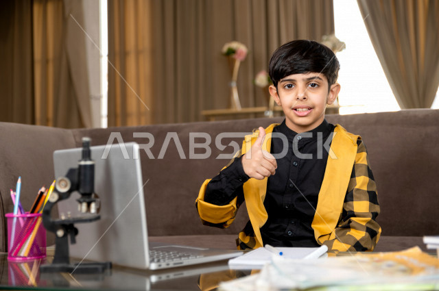 A Saudi Gulf student studying at home with different facial expressions, following online classes via a laptop, distance learning, the concept of online education, home education during quarantine and the outbreak of the Corona virus, self-isolation