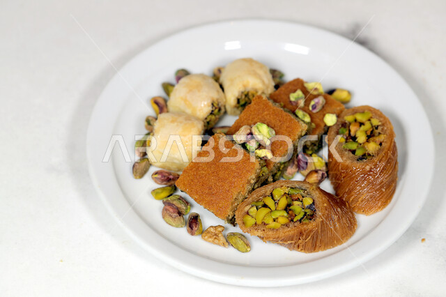 طبق يحوي قطع متنوعة من البقلاوة بالمكسرات، حلويات وسكريات،  قطع الحلوى الشهية و اللذيذة، حلا شرقي، التحلاية، حلويات رمضانية