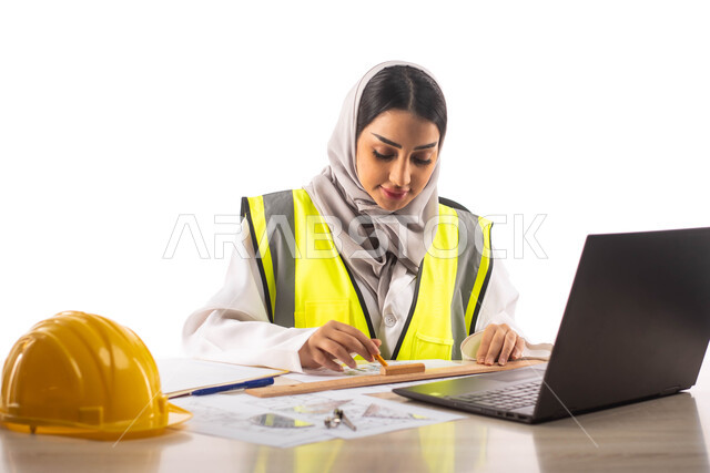 The use of engineering tools and equipment on an engineering design plan, a portrait of a professional Saudi Arabian Gulf architect inside an engineering office, the use of a laptop computer for achievement and task tracking, a protective helmet, professi