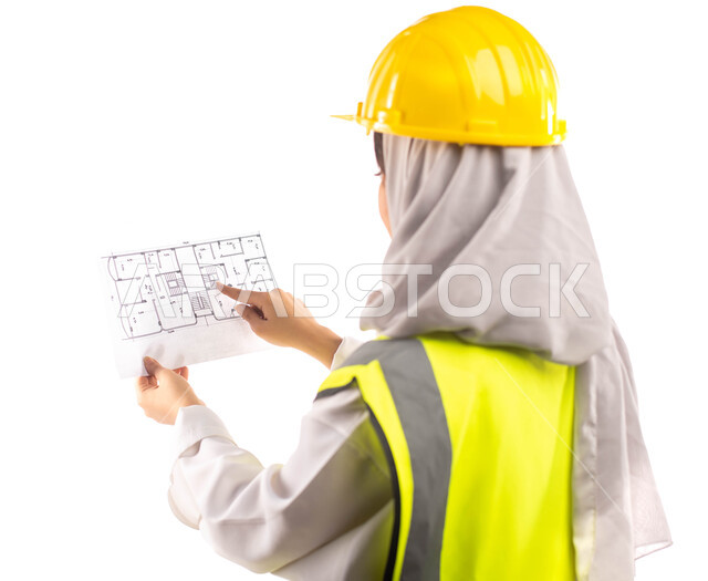  ارتداء بدلة السلامة والخوذة الخاصة  في العمل ، بورتريه من الخلف لمهندسة انشاءات معمارية عربية سعودية خليجية محترفة تحمل بيدها مخطط البناء ، مخططات وتصاميم هندسية، مهن ووظائف هندسية، خلفية بيضاء
