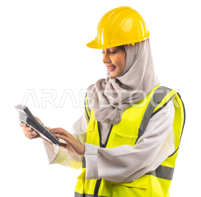  ارتداء خوذة وسترة الحماية الخاصة بالعمل, استخدام الآلة الحاسبة لإجراء العمليات الحسابية ,مخططات و تصماميم هندسية, ادارة المشاريع الهندسية، بورتريه  لمهندسة معمارية عربية خليجية سعودية محترفة, مهن و وظائف هندسية .