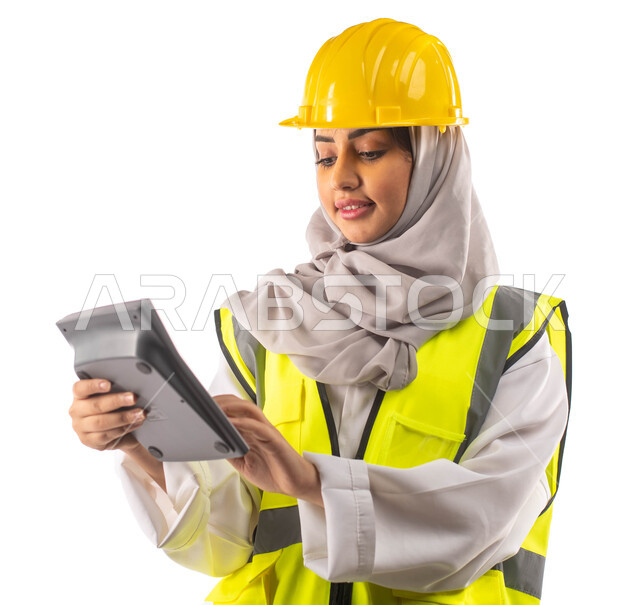 Engineering plans and designs, using a calculator to perform calculations, managing engineering projects, a portrait from behind of a professional Saudi Arabian Gulf architect wearing a helmet and work protection jacket, engineering professions and jobs.