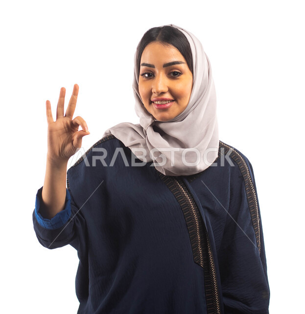 الإعجاب والرضى و الإمتياز والتميز, بورتريه لامرأة عربية خليجية سعودية محجبة ترتدي العباءة السوداء, ايماءات يدين تدل على علامة الجوده, خلفية بيضاء