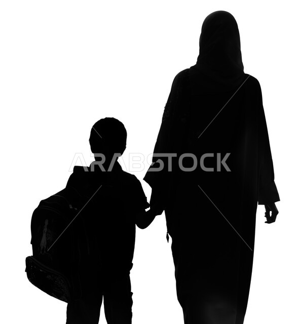 Studying in the Kingdom of Saudi Arabia, a portrait of a silhouette from the back of a Saudi Arabian Gulf mother holding the hand of her child and driving him to school, a Saudi student wearing his schoolbag with his mother, the bond of motherhood, prepar
