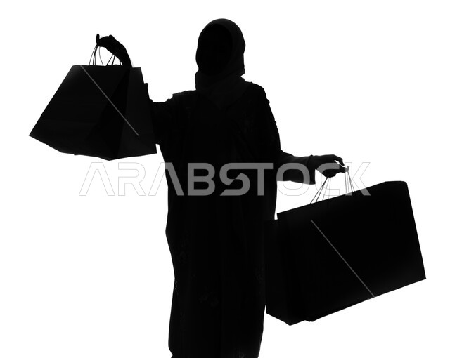 متعة الشراء في السعودية, الجمعة البيضاء والشراء من الماركات العالمية، بورتريه صورة ظلية لإمرأة عربية خليجية سعودية تحمل بيدها أكياس التسوق, إيماءات تدل على السعاده والاستمتاع بالتبضع, خلفيه بيضاء, سيلوليت