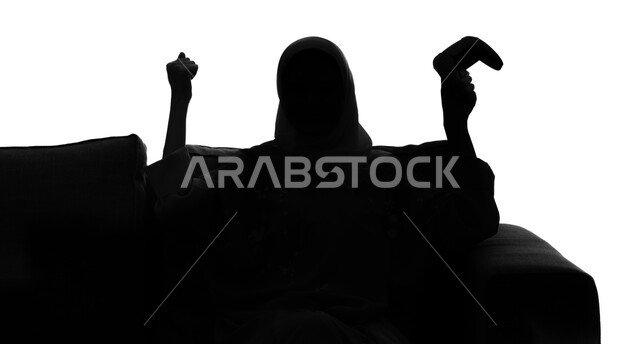 إيماءات وتعابير  تدل على الفوز و الانتصار, قضاء أوقات الفراغ باللعب بألعاب البلايستيشن الترفيهية ، تقنيات حديثة مسلية, بورتريه صورة ظلية لإمرأة عربية سعودية خليجية تجلس على أريكة مريحة وتحمل بيدها عصا التحكم  و تلعب بألعاب الفيديو ، خلفية بيضاء, سيلوليت