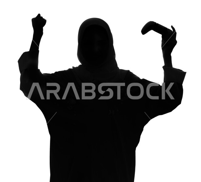 إيماءات و تعابير تدل على الفوز و الانتصار، المتعة والمرح بألعاب الفيديو والبلايستيشن الترفيهية , بورتريه صورة ظلية لإمرأة عربية خليجية سعودية تمسك بيدها عصا التحكم و تلعب بألعاب الفيديو، ممارسة أنشطة ترفيهية مسلية, خلفية بيضاء, سيلوليت