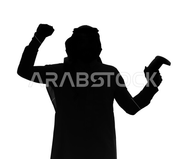المتعة والمرح بألعاب الفيديو والبلايستيشن الترفيهية , بورتريه صورة ظلية لرجل عربي خليجي سعودي يرتدي الزي السعودي و يمسك بيده عصا التحكم و يلعب بألعاب الفيديو ، بإيماءات و تعابير تدل على الفوز و الانتصار، خلفية بيضاء, سيلوليت